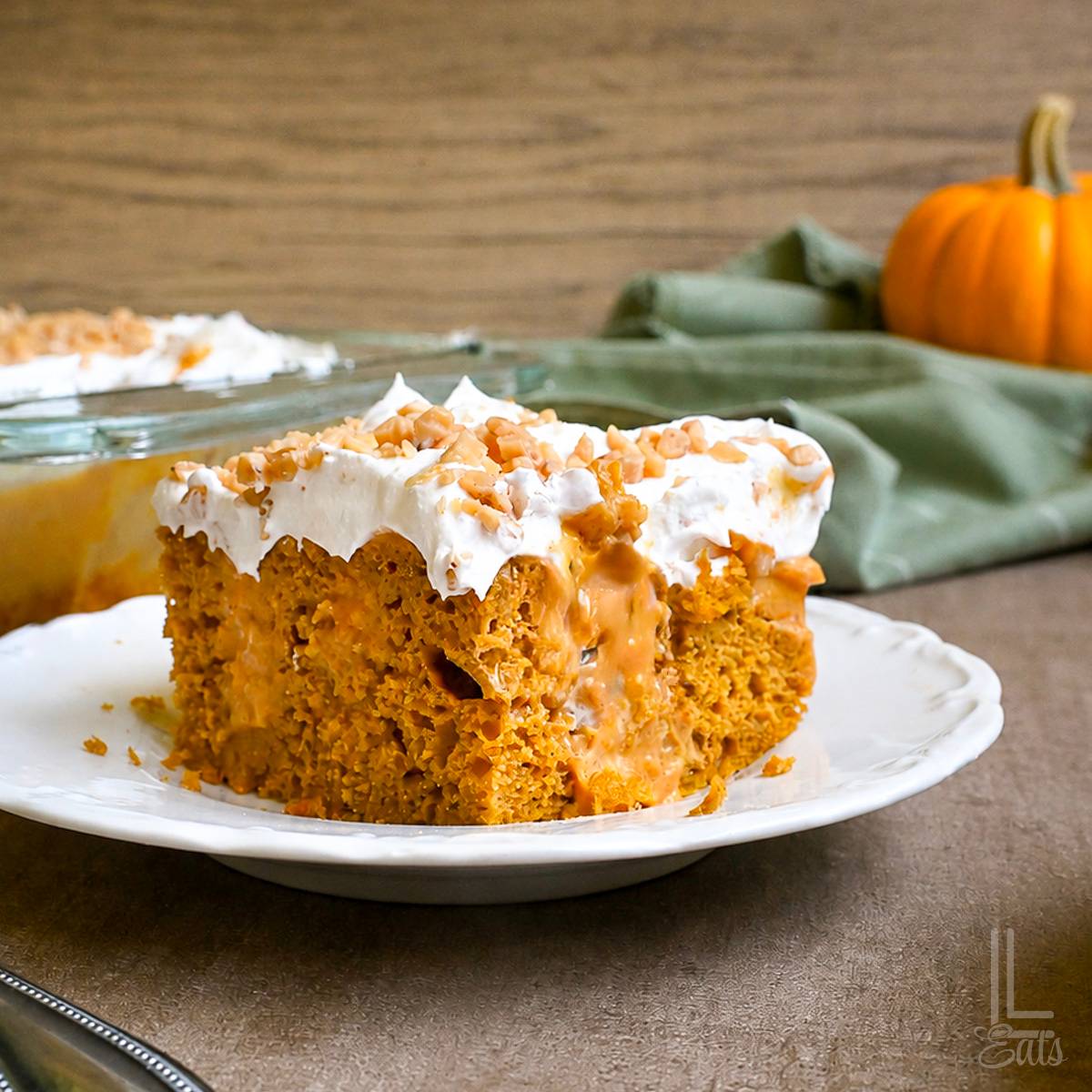 piece of pumpkin poke cake on a plate.
