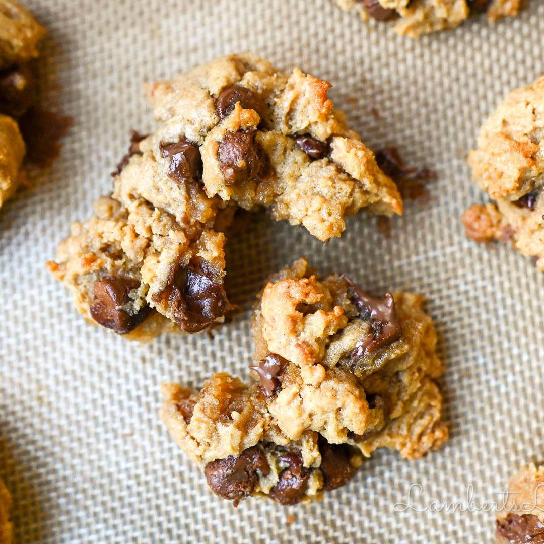 peanut butter chocolate chip cookie torn apart on a cookie sheet.