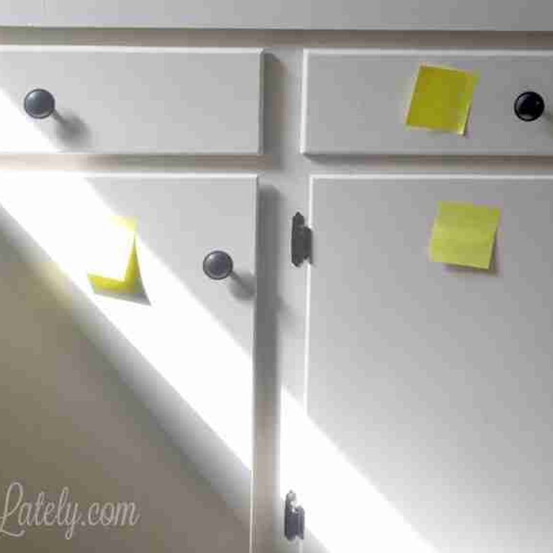 Organized white pantry cabinets with labeled storage zones and sticky note labels for maintaining a clutter-free moving system.