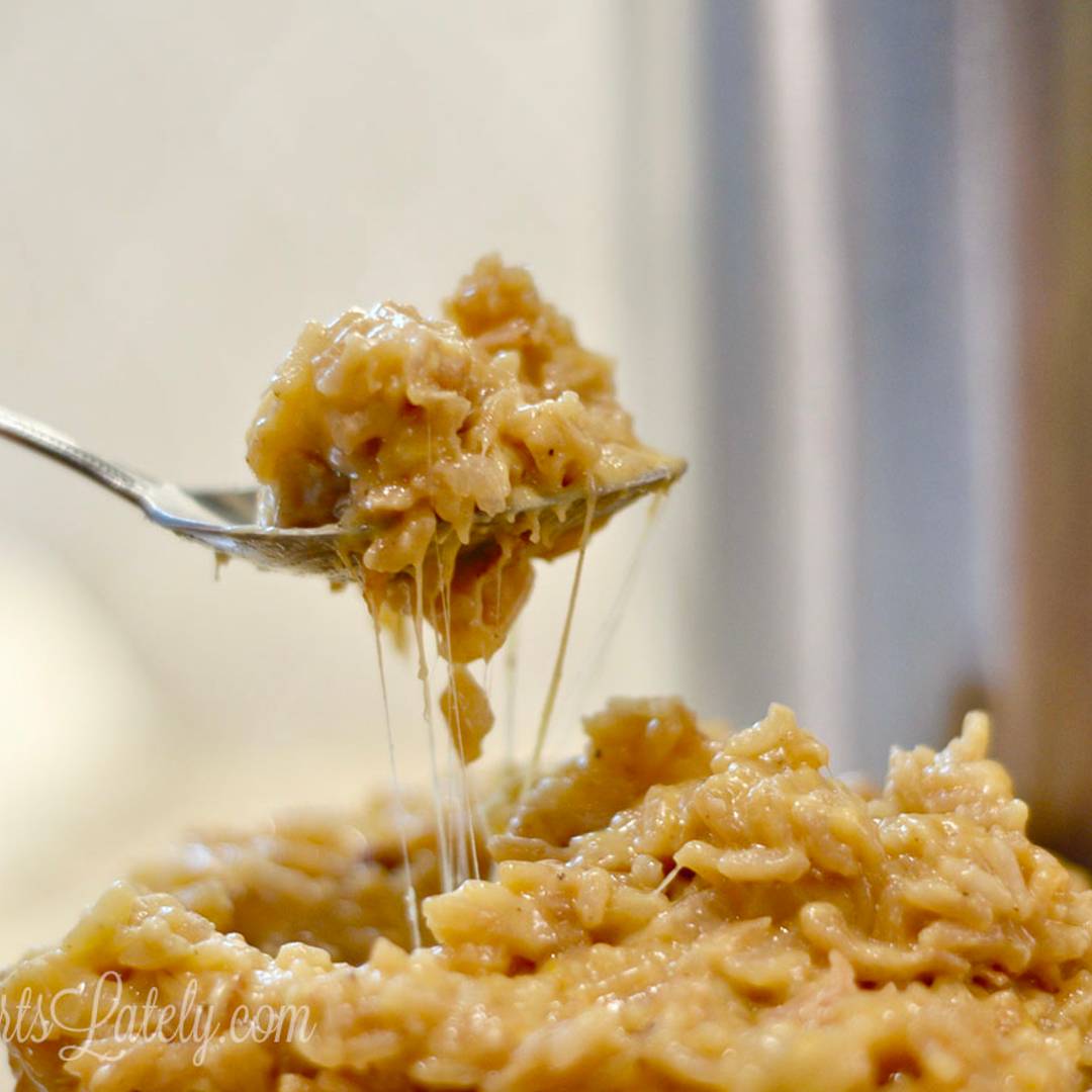 holding a fork full of cheesy chicken and rice.
