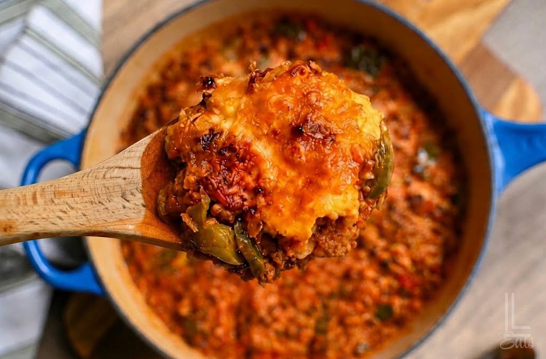 holding a spoonful of unstuffed peppers above a dish.