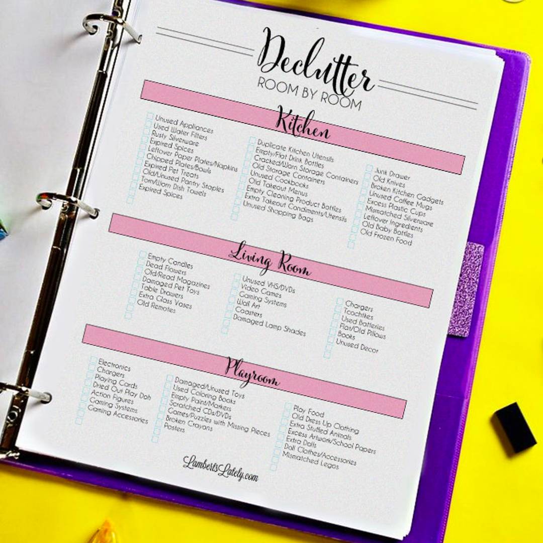 A purple binder open to a "Declutter Room by Room" checklist, featuring pink-coded sections for the kitchen, living room, and playroom with checkboxes for items to purge.