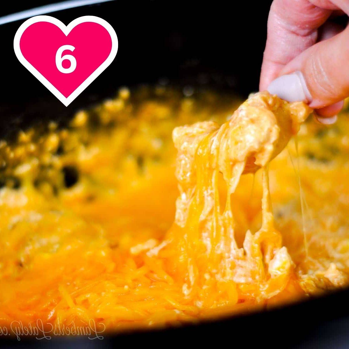 #6 - scooping buffalo chicken dip out of a crock pot with a chip.