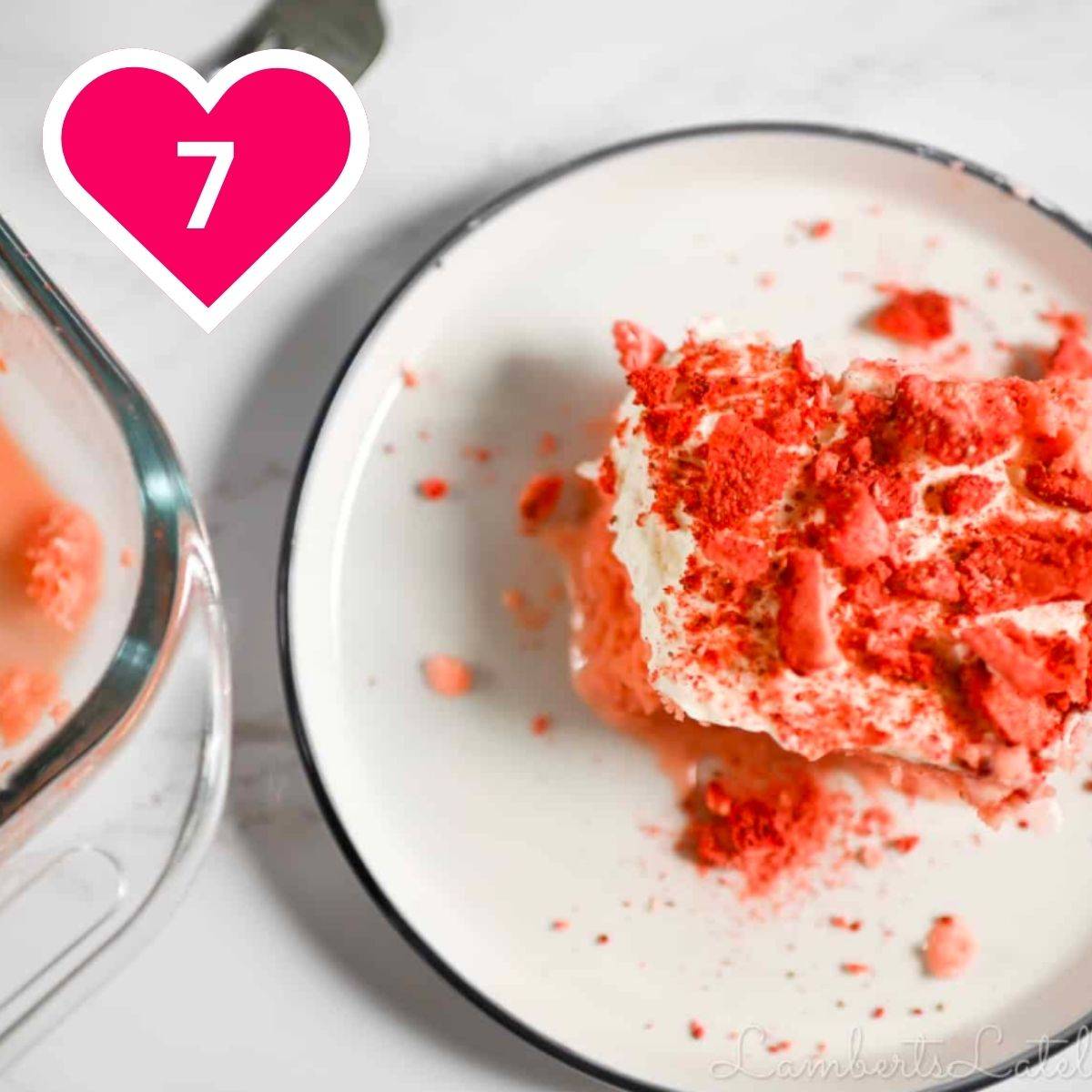 7 - strawberry tres leches cake on a plate, next to serving dish.