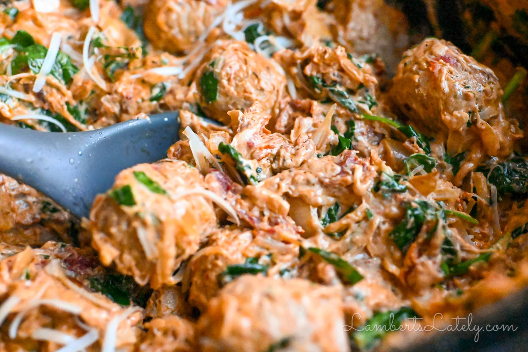 chicken meatballs in a creamy sauce, with spinach and tomatoes.