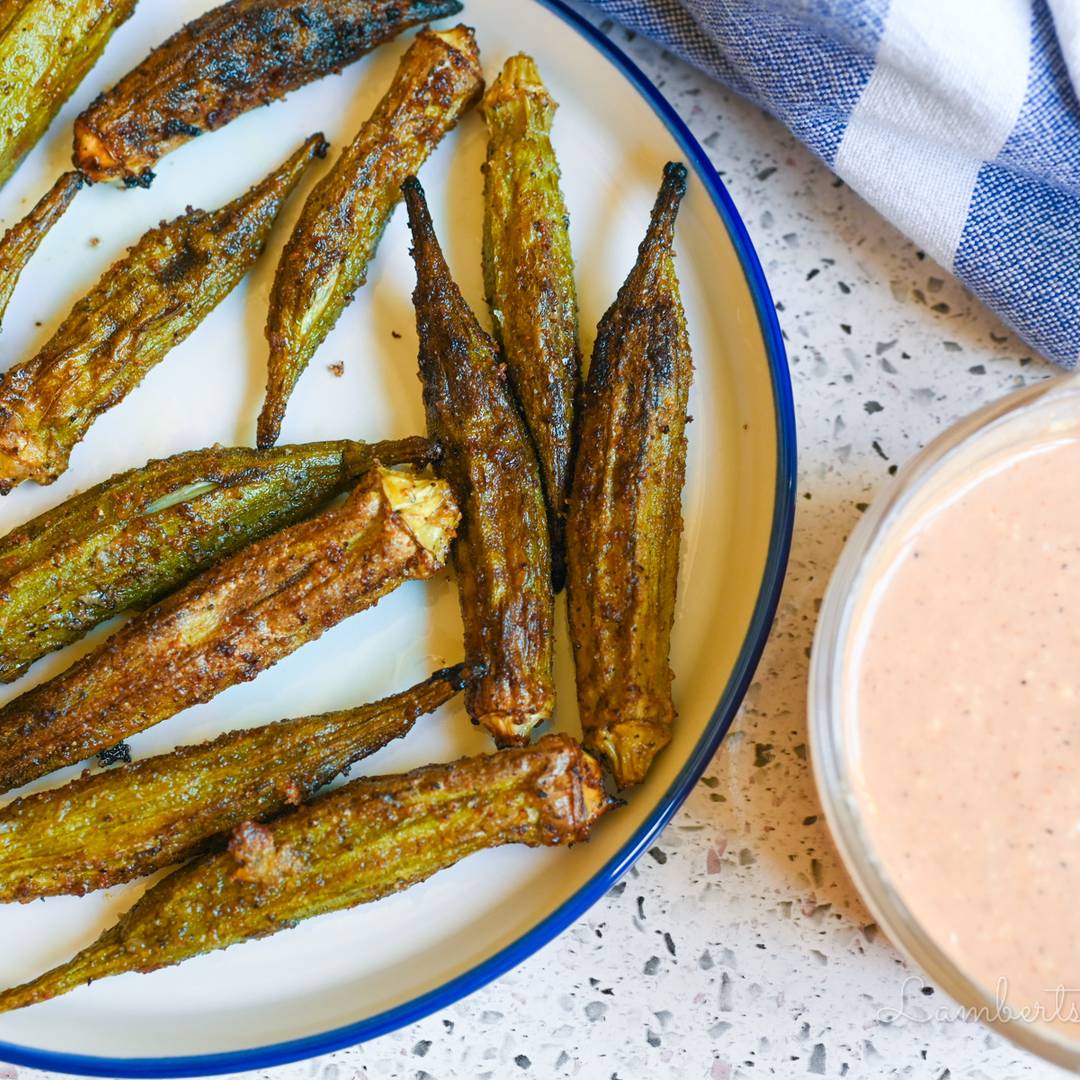 okra cooked and on a plate, next to dipping sauce.