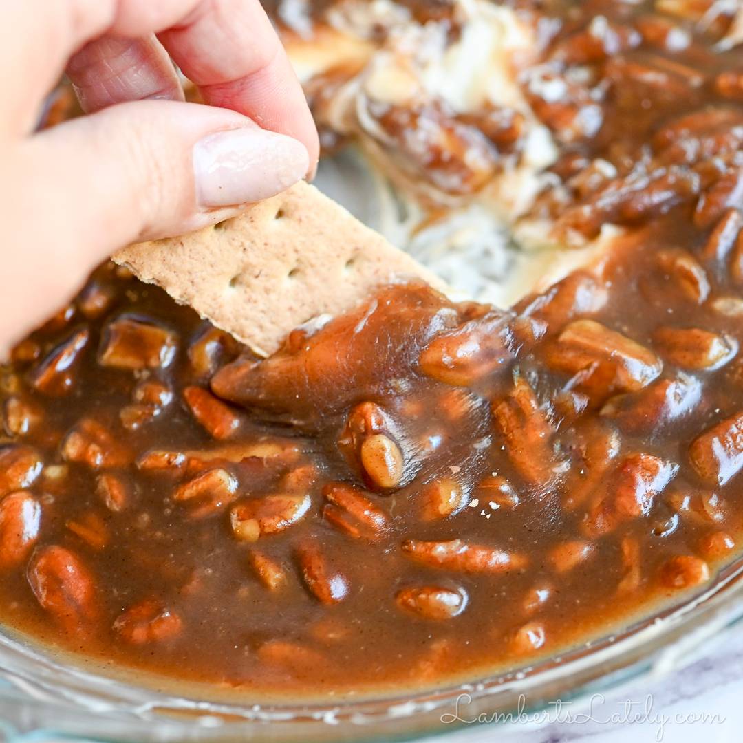 scooping pecan pie dip with a graham cracker.