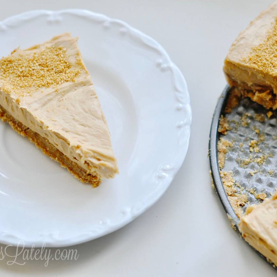 A slice of creamy cookie butter pie on a white plate, showing the thick biscoff-flavored filling and a fine cookie crumb topping.