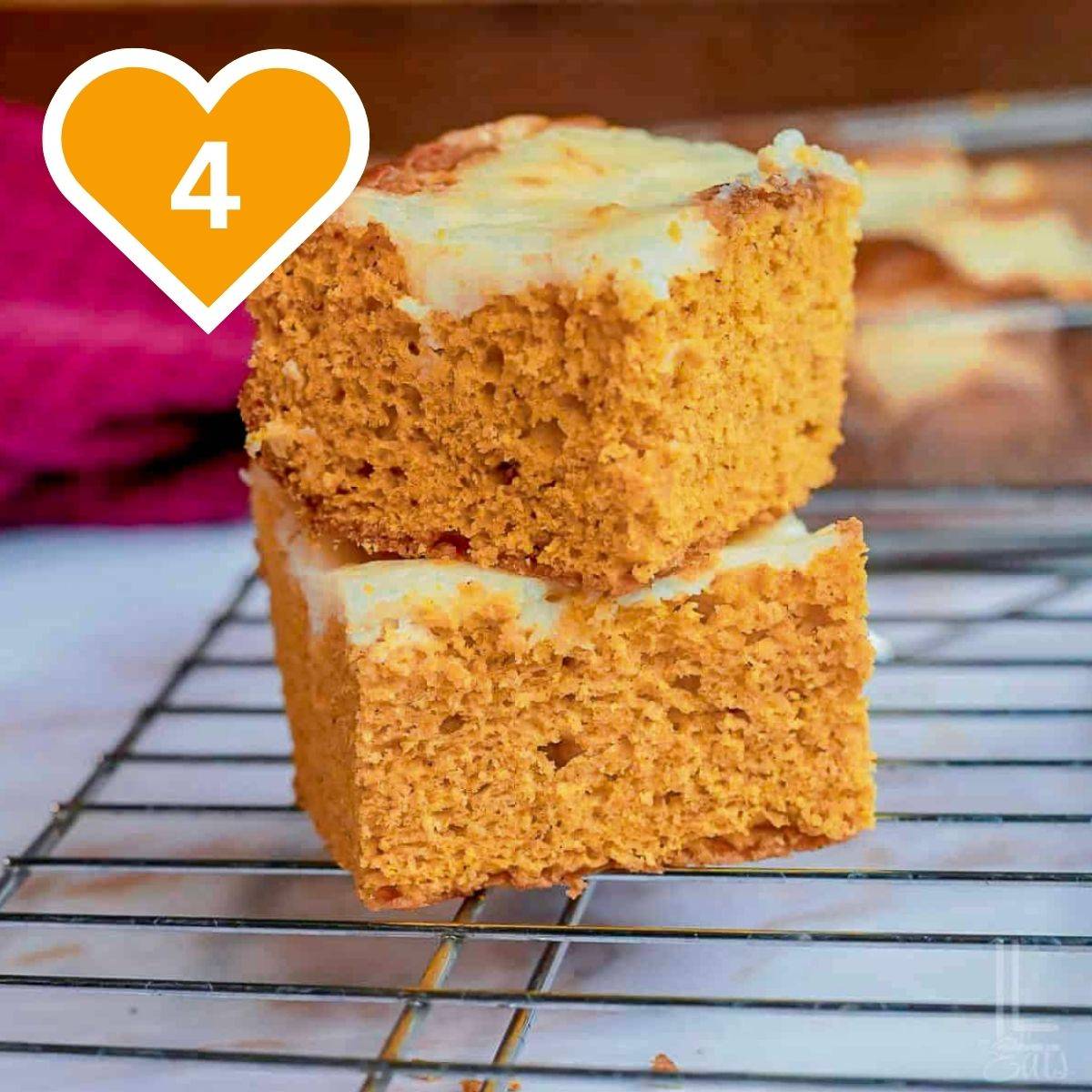 Two thick pumpkin bars with a golden crust cooling on a wire rack.