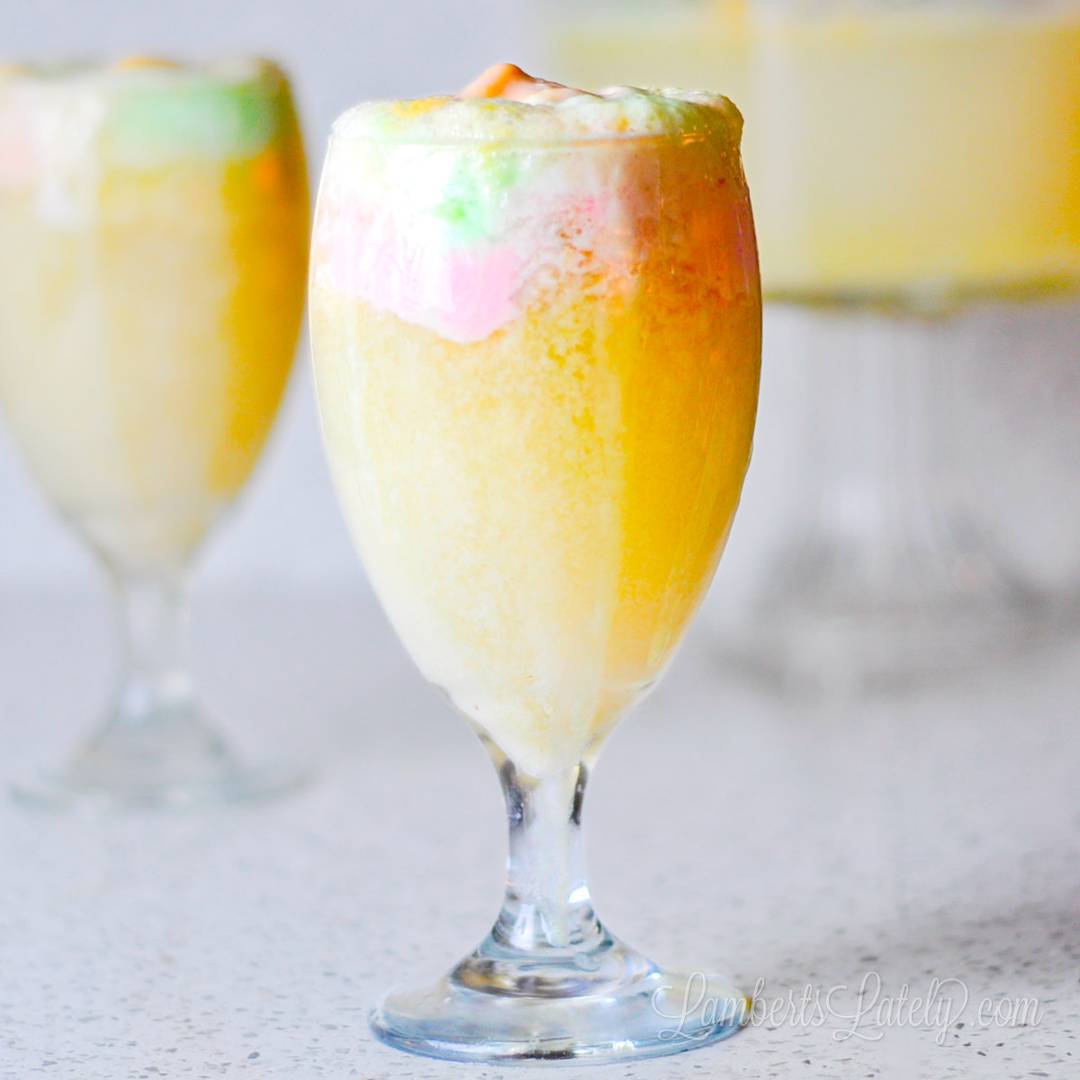 cups of rainbow sherbet punch in front of a serving bowl.