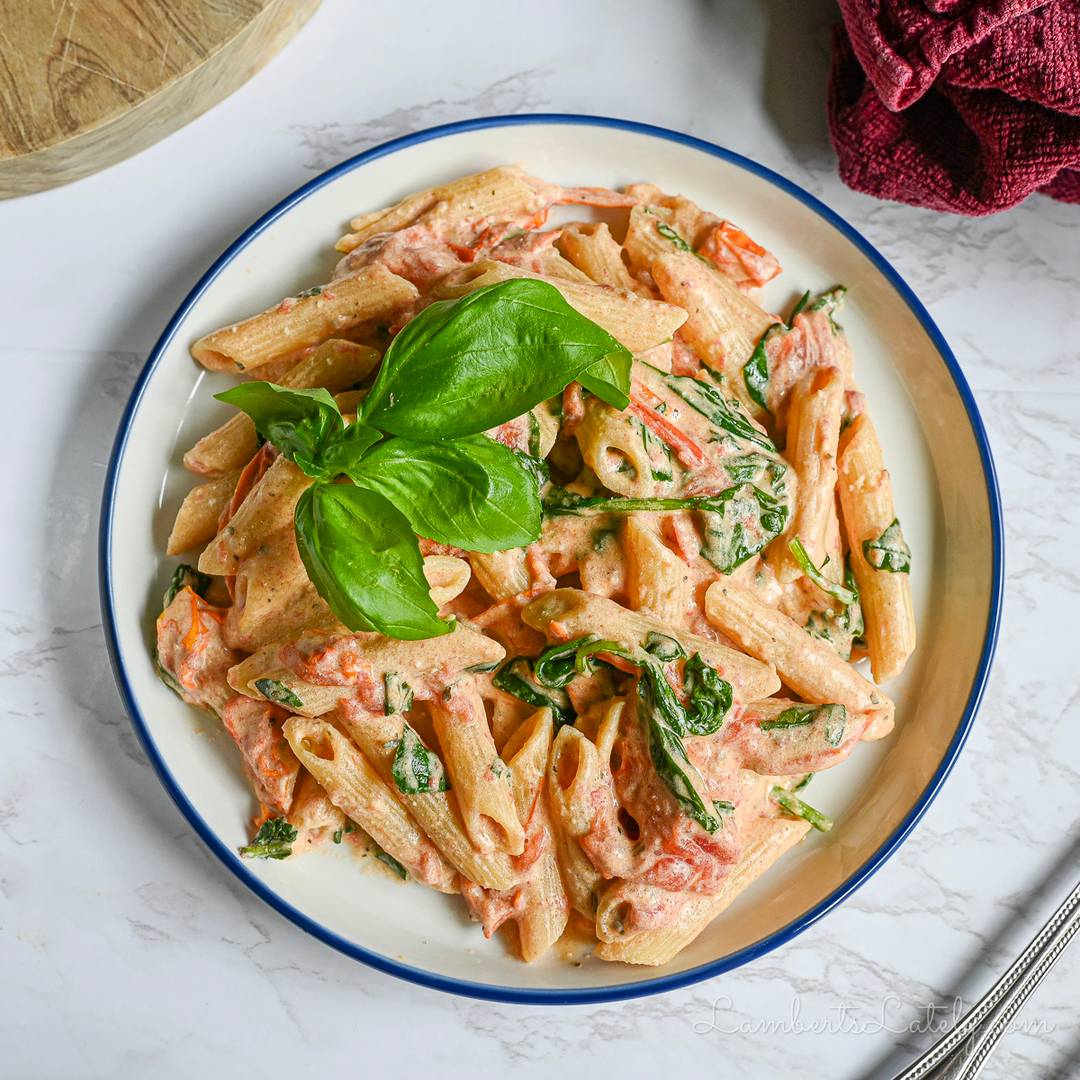 Creamy Boursin cheese penne pasta with tomatoes, spinach, and fresh basil.
