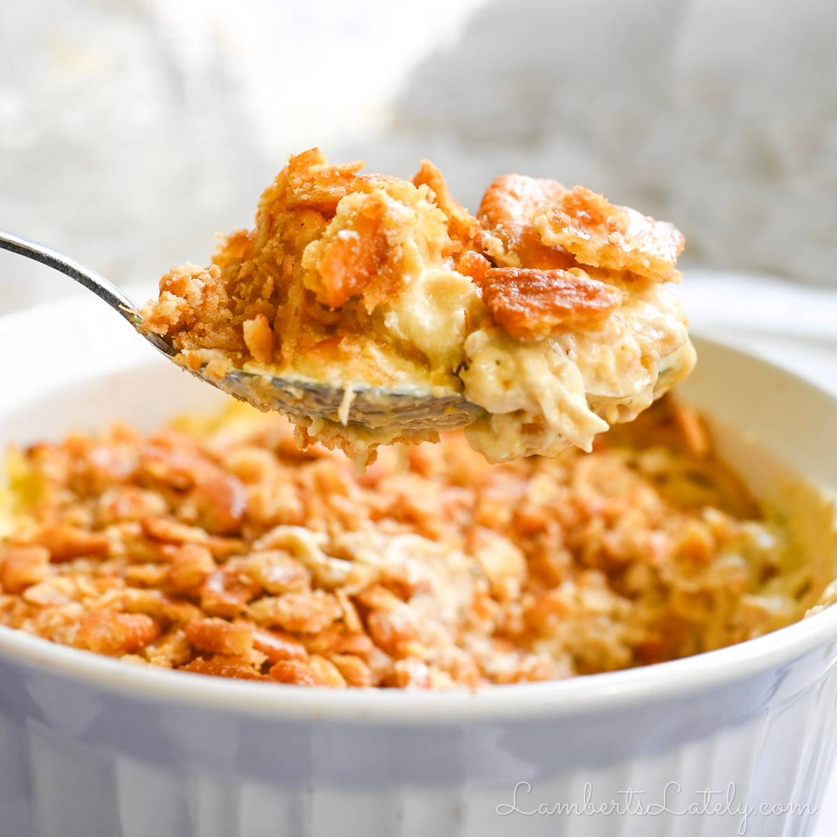 holding a spoonful of ritz cracker chicken casserole above a casserole dish.