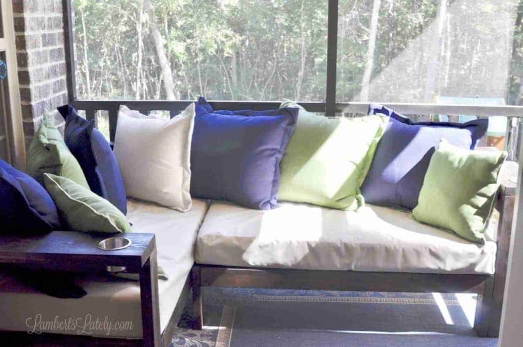 ourdoor sectional on a screened porch, with pillows.