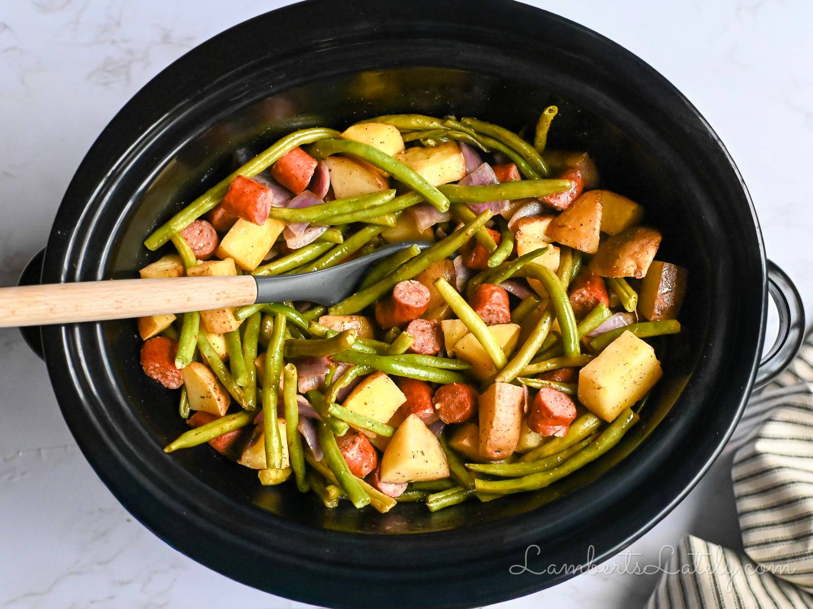 swamp potatoes with sausage and green beans in a crock pot.