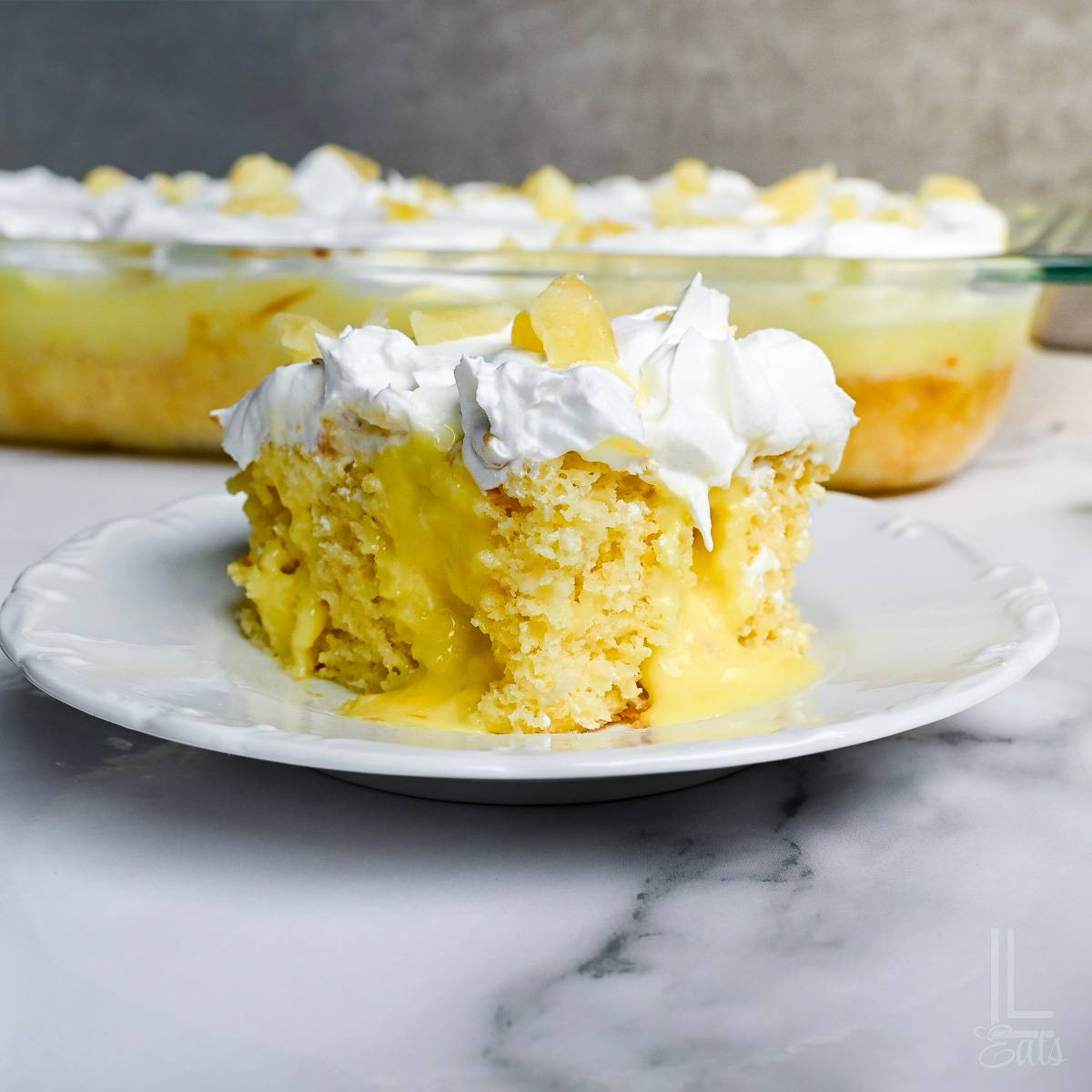 piece of pineapple poke cake on a plate.