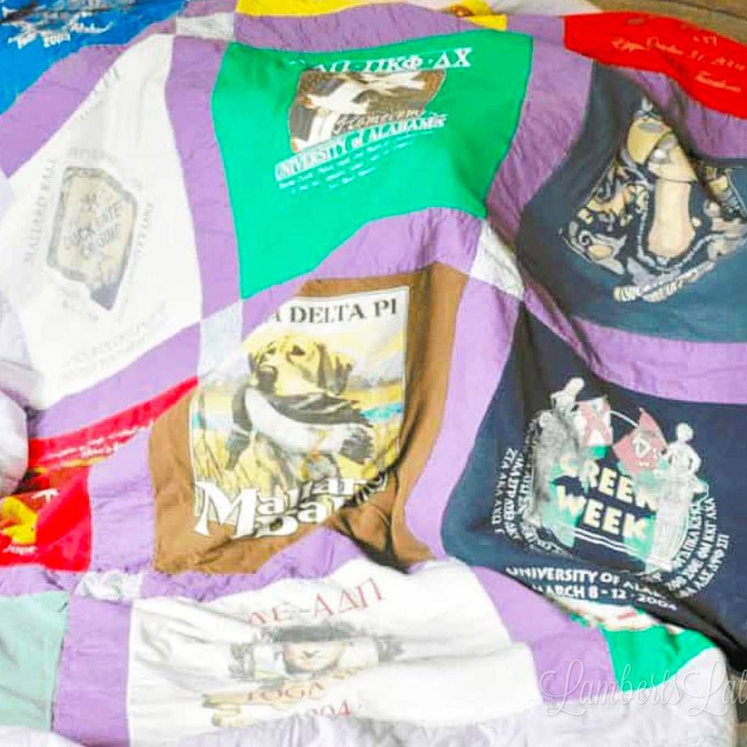 A colorful DIY t-shirt quilt made from various collegiate and event shirts in shades of purple, green, and white.