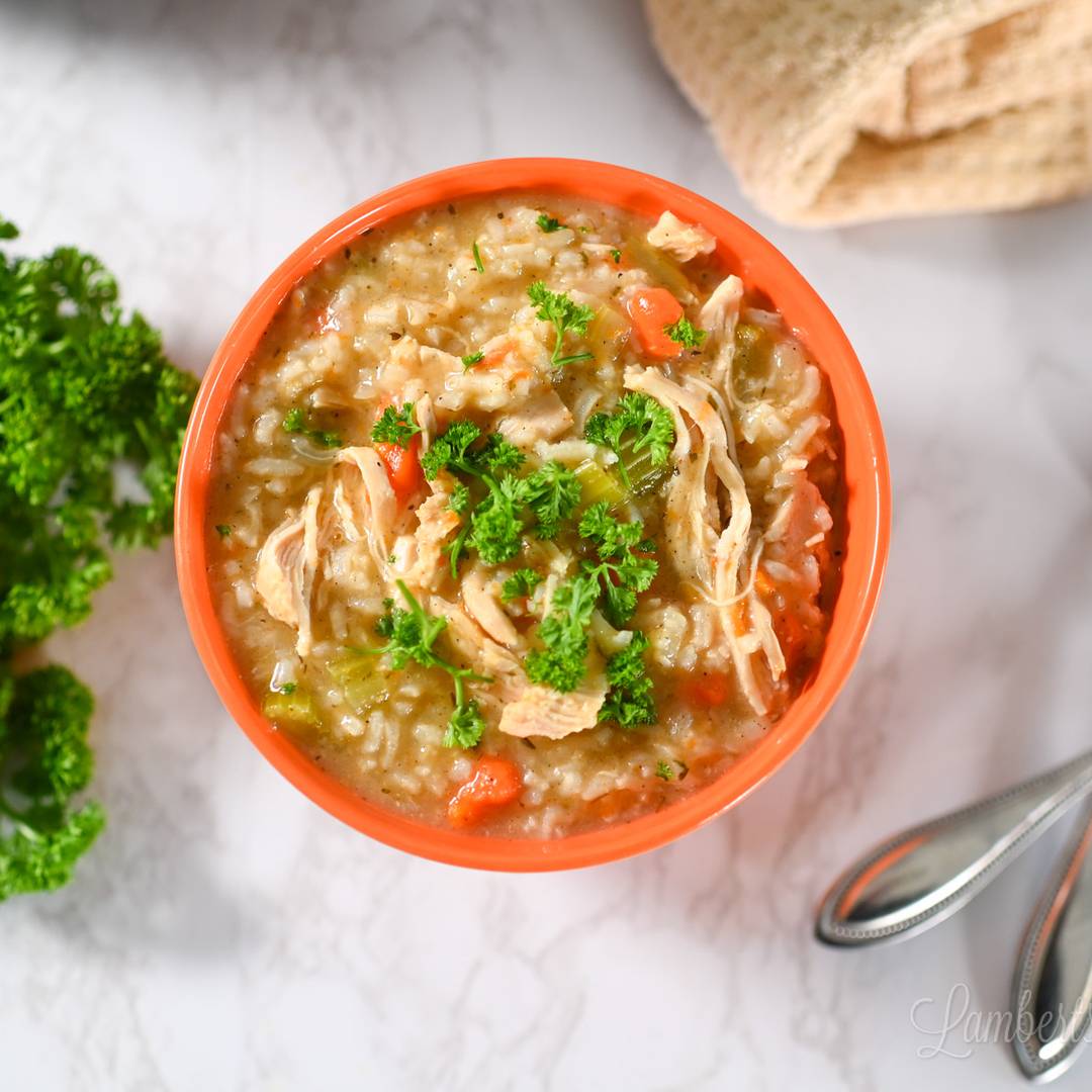 chicken and rice soup in a bowl, topped with parsley.