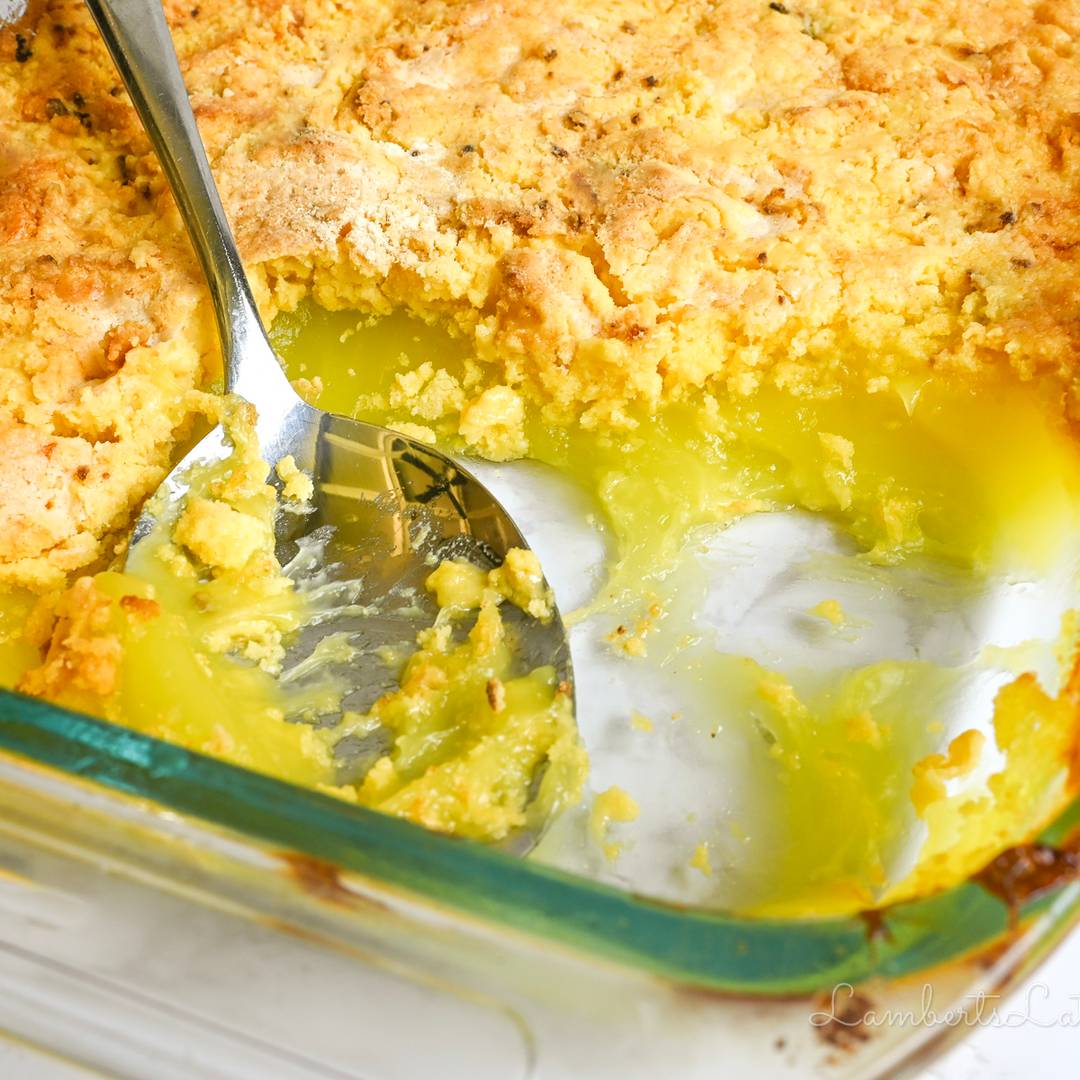 looking into a pan of lemon dump cake, servings missing, with a spoon.
