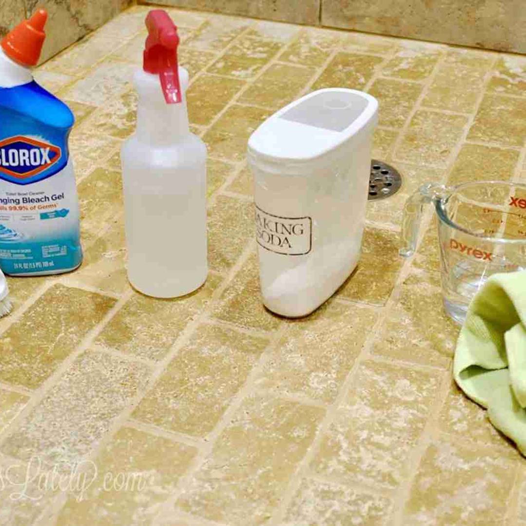various cleaners on the floor of a tile shower.