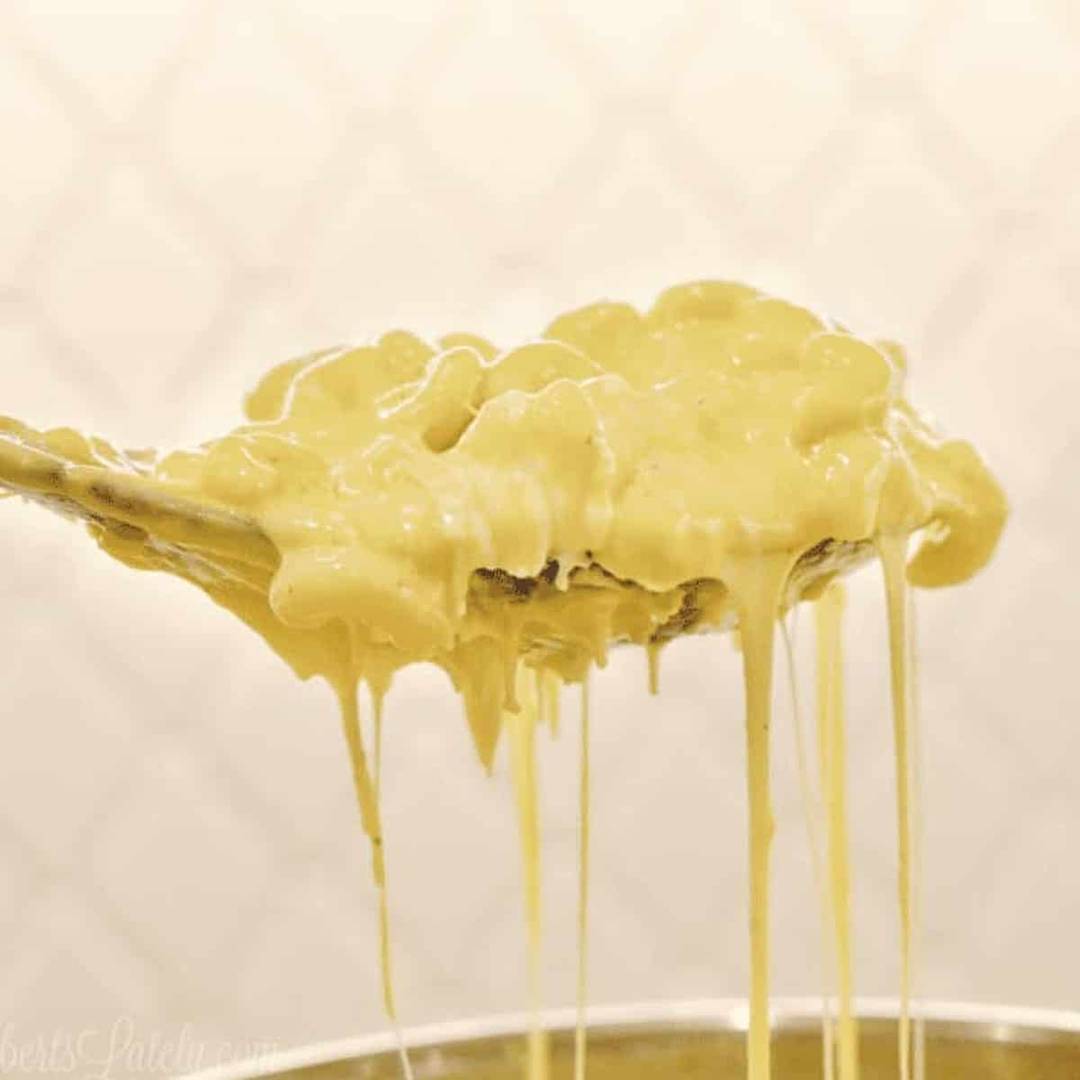 holding a spoonful of mac and cheese above an instant pot.