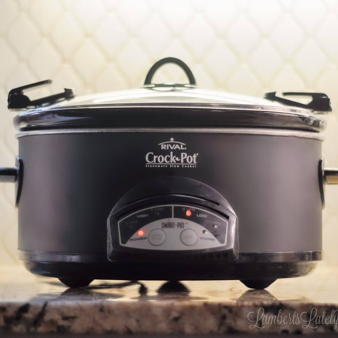A black Crock-Pot slow cooker turned on during kitchen meal prep.