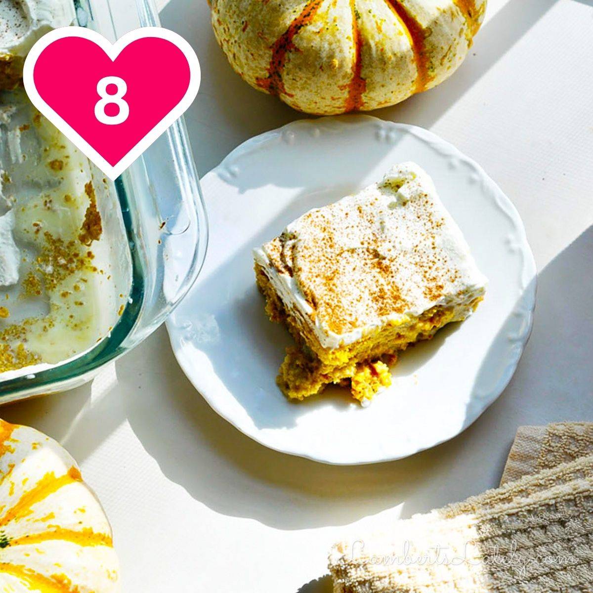 #8 - pumpkin tres leches cake on a plate, next to pumpkin, baking dish.