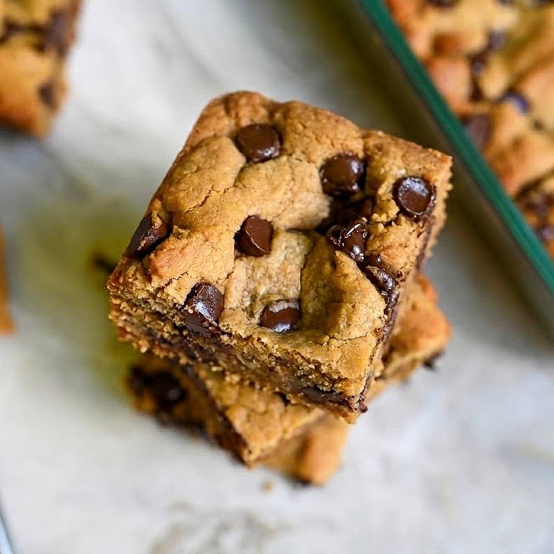 Stacked peanut butter cookie bars filled with chocolate chips.