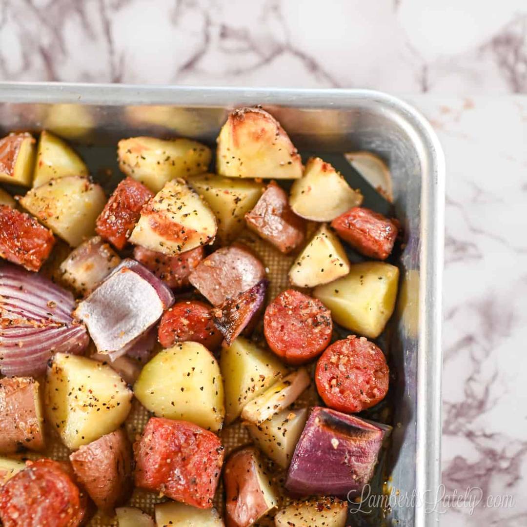 sausage, potatoes, and onions on a sheet pan.