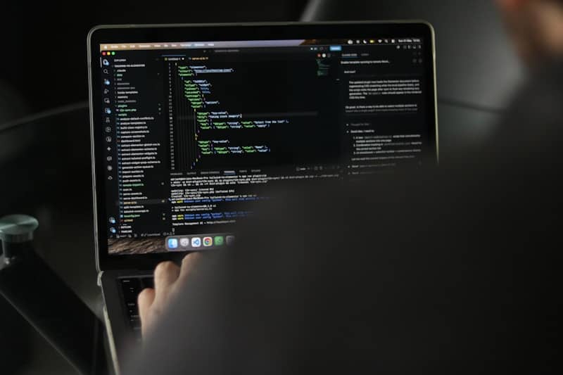Person typing code on a laptop screen.