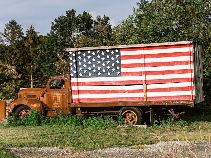 Rusty truck with american flag painted on side