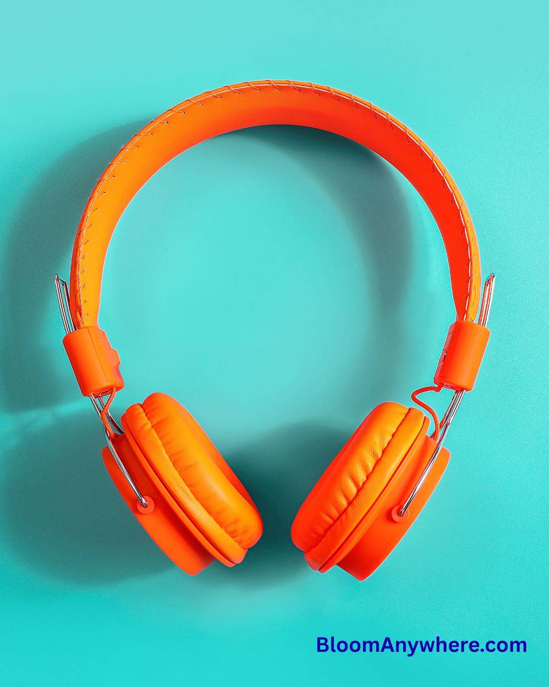 Orange headphones against a teal background