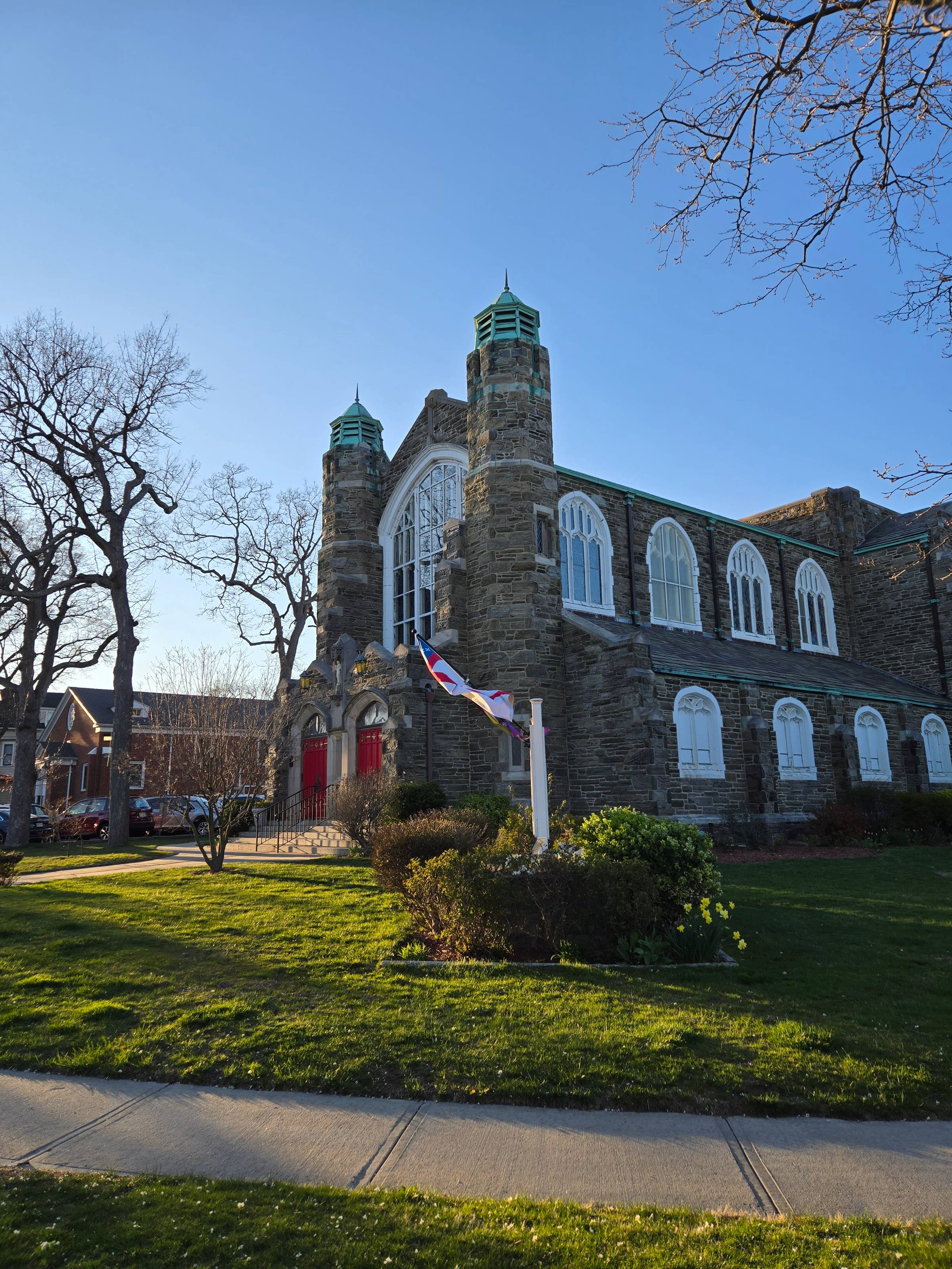 A grey brick church with a bright red door