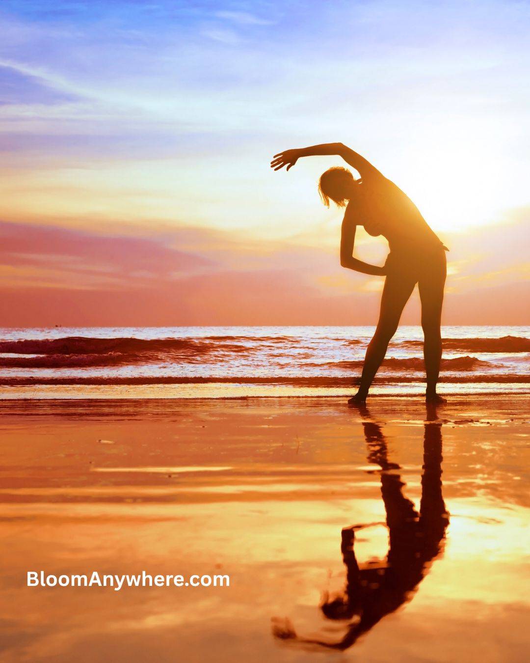 A woman stretching with her arm over her head at the edge of the ocean