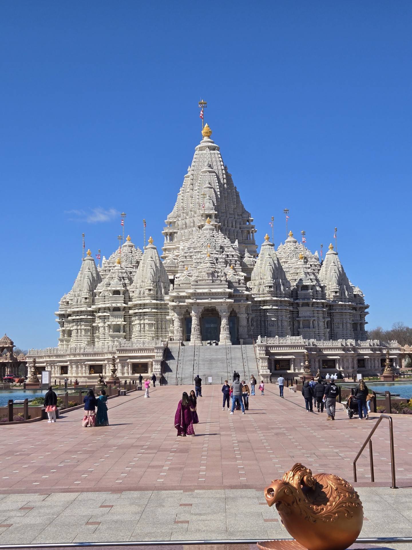 A photograph of a Hindu temple carved of white stone against a blue sky