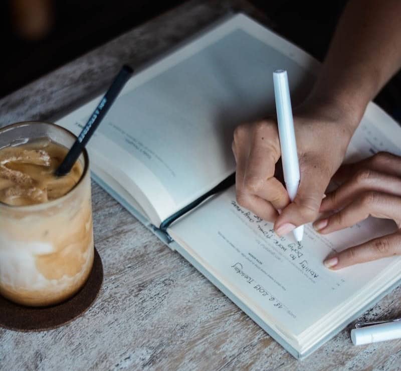 person writing on book