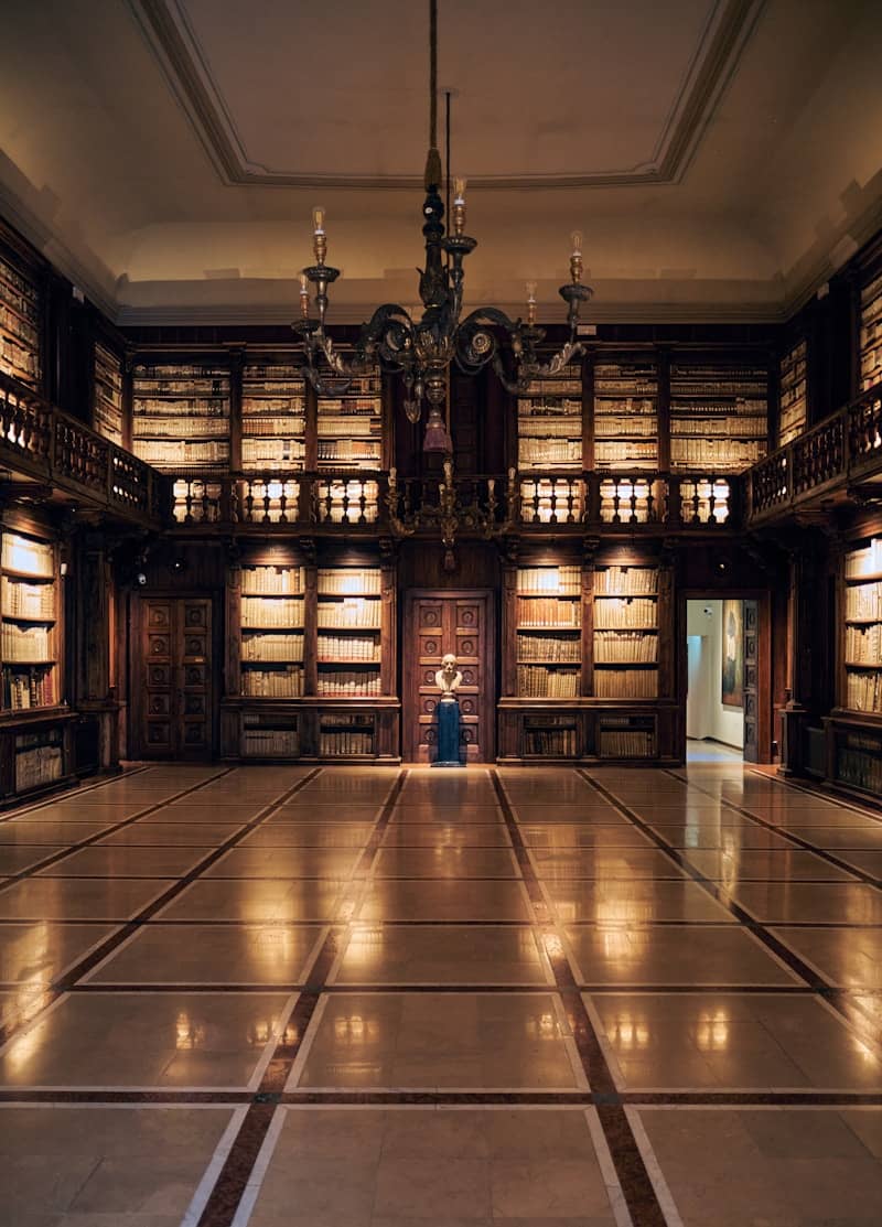 An elegant library with books and a chandelier.
