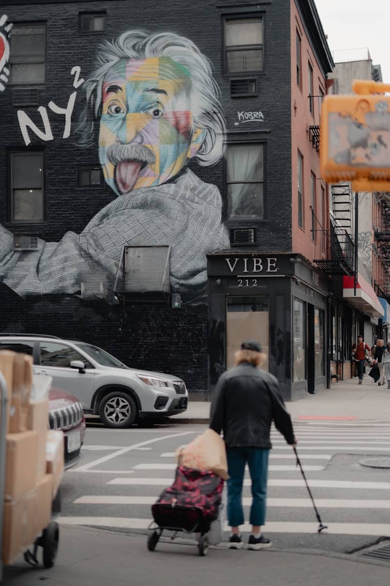 Street scene featuring an einstein mural and pedestrian.