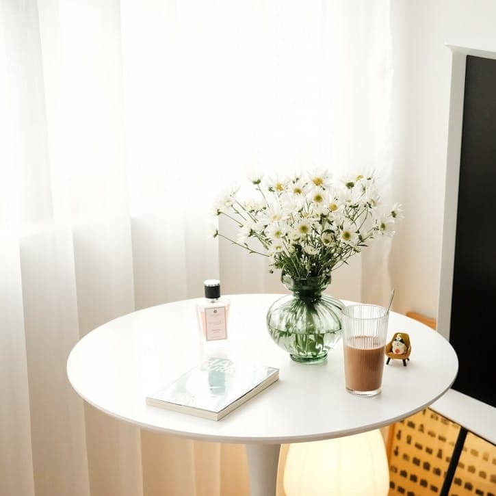 A white table with a vase of flowers on top of it