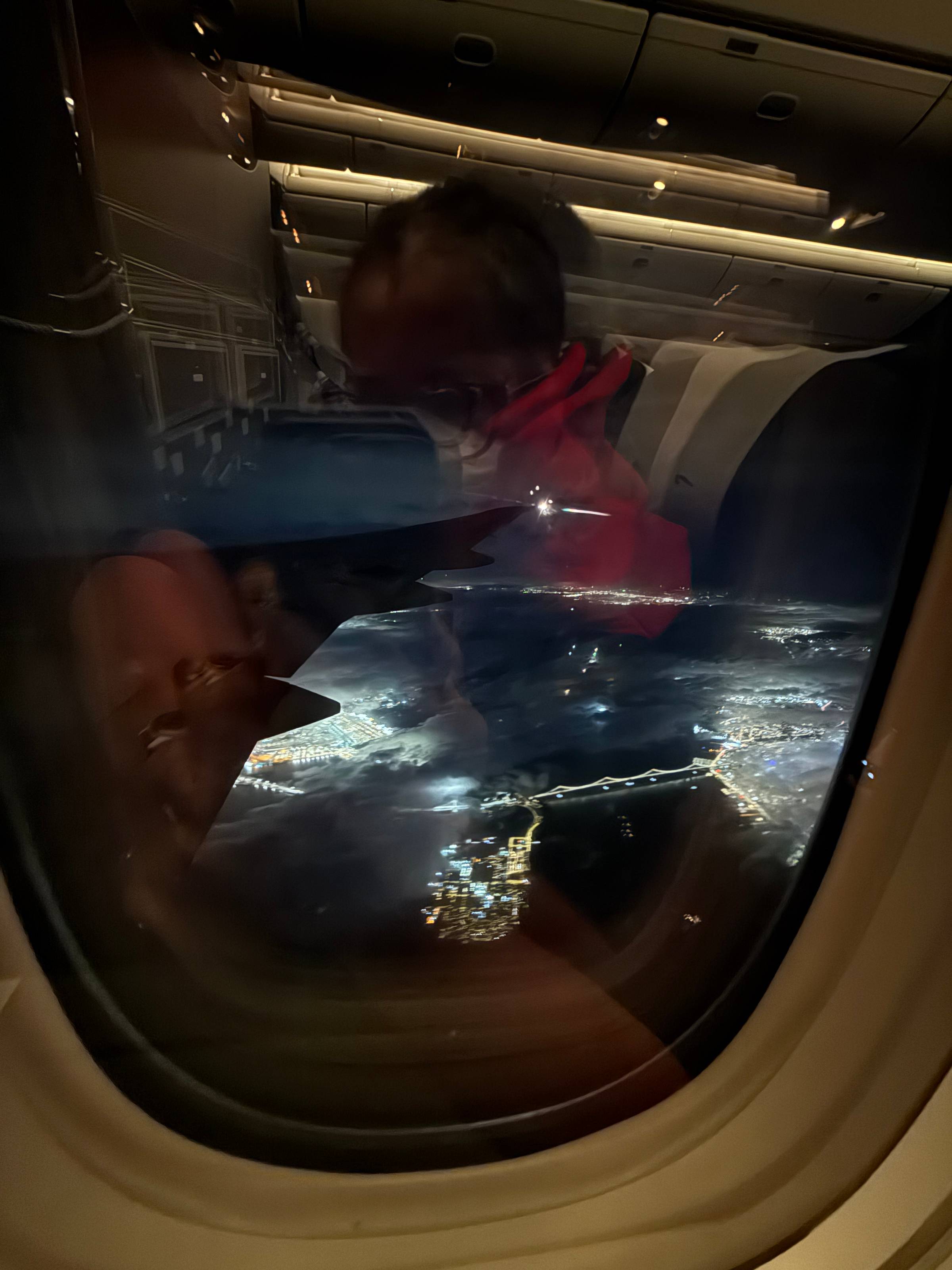 photo taken through the airplane window when leaving San Francisco, with bay bridge and partial self reflection showing