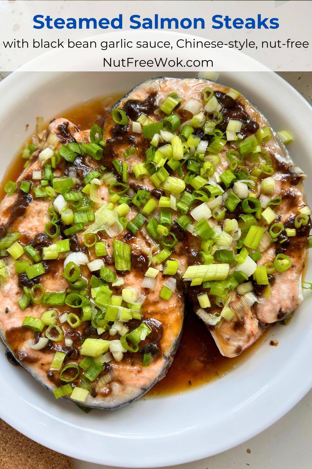 steamed salmon steak topped with chopped scallions in a white serving plate