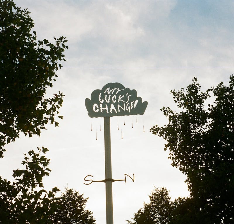 Image of a cloud-shaped sign reading "my luck's changed".