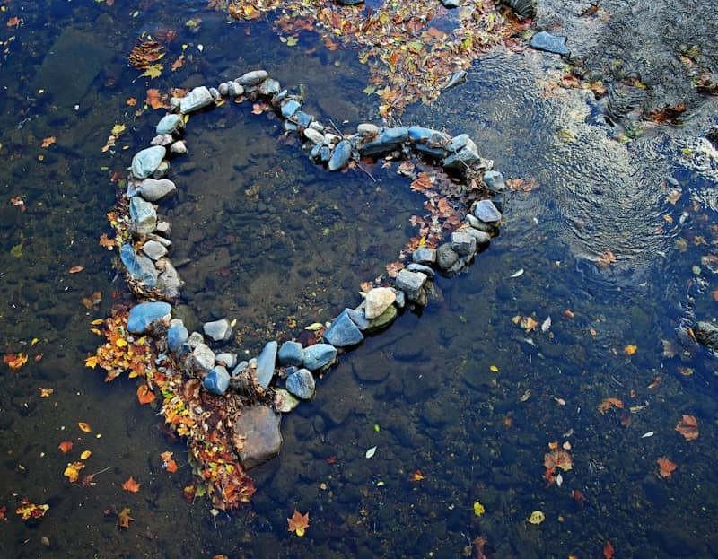 A heart made out of rocks in the water