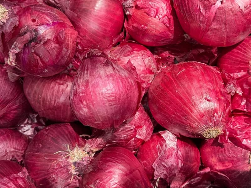 Here is a possible caption: a pile of red onions.