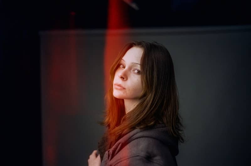 A woman standing in front of a red light
