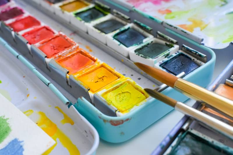 A set of watercolor paints with brushes