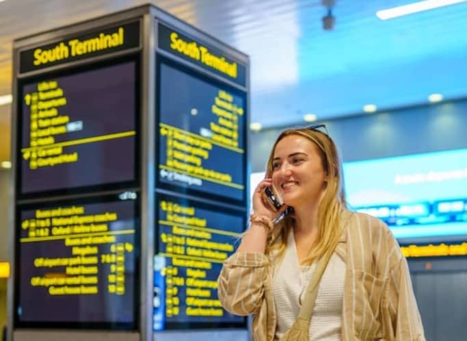 Woman talking on phone near south terminal departure board