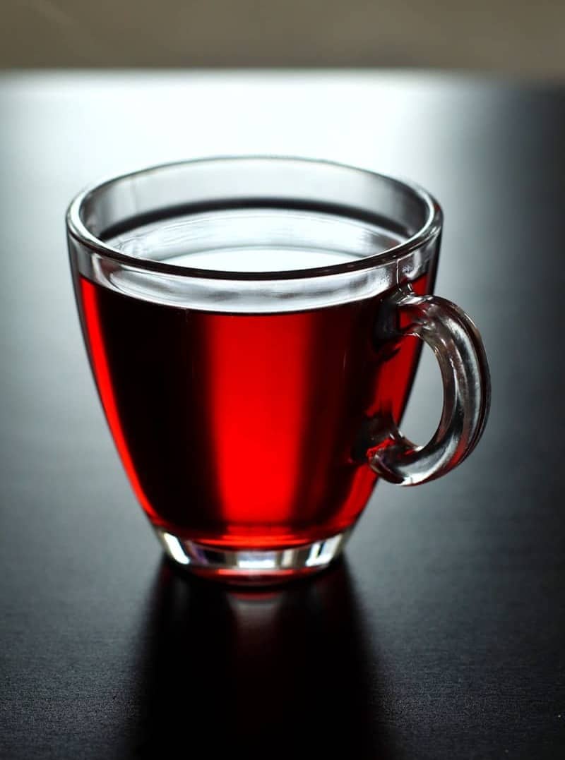 A glass cup of tea sitting on a table