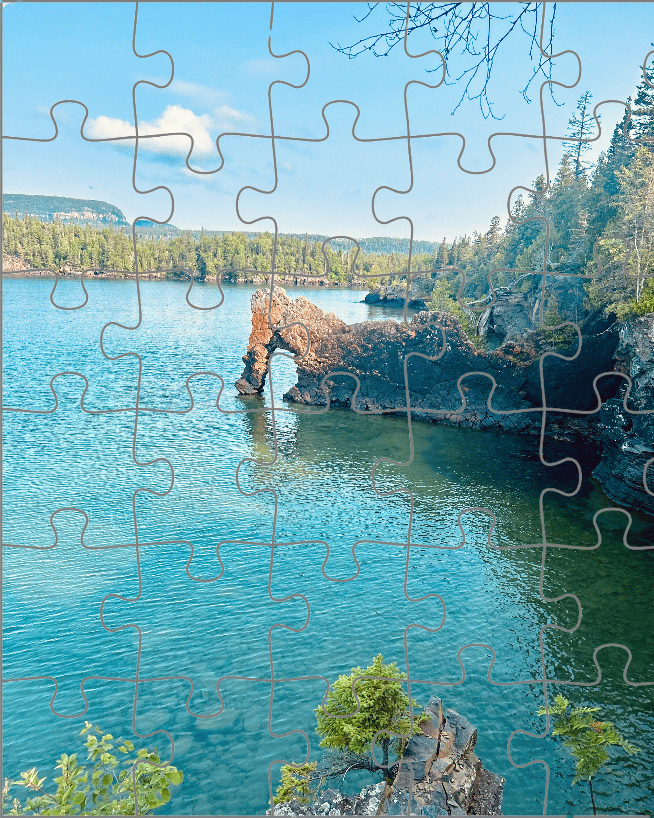 A photo of a natural rock arch on turquoise water, framed by puzzle piece outlines. The scene remains whole beneath the illusion of separation.