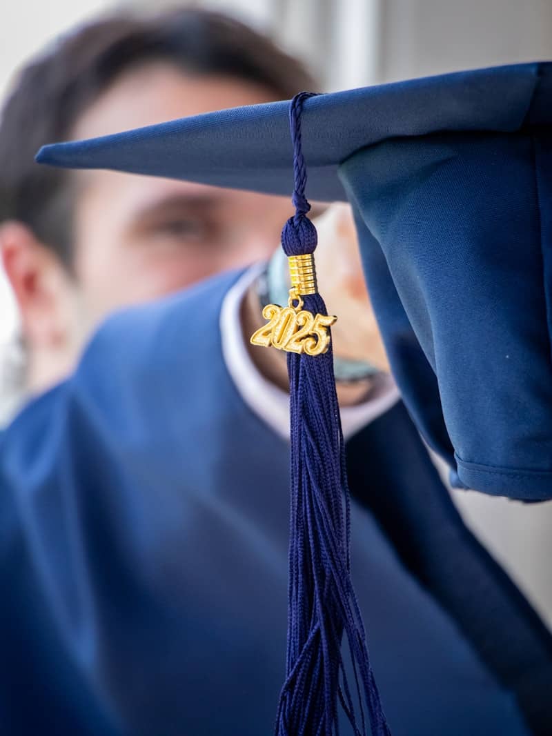 Celebrating graduation, holding a cap with the year.