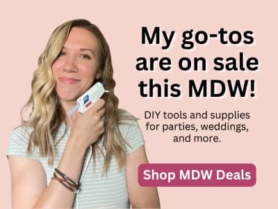A woman holding up a hot glue gun with overlaid text that reads "My go-tos are on sale this MDW: DIY tools and supplies for parties, weddings, and more. Shop MDW Deals."